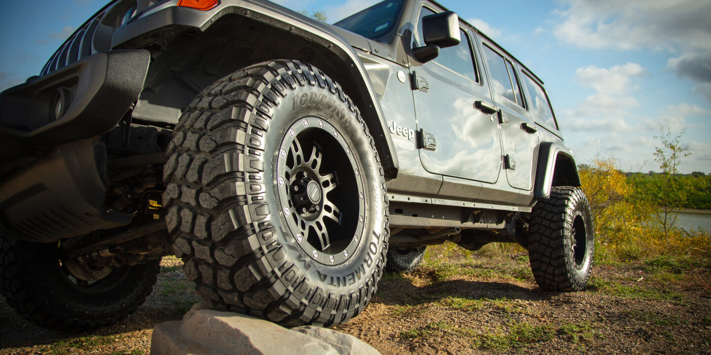 Tormenta M/T on a Jeep driving over a rock